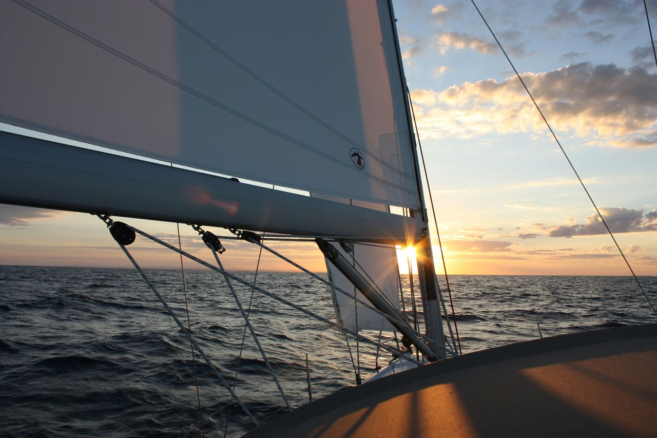 sail of a sailboat at sunset on the ocean